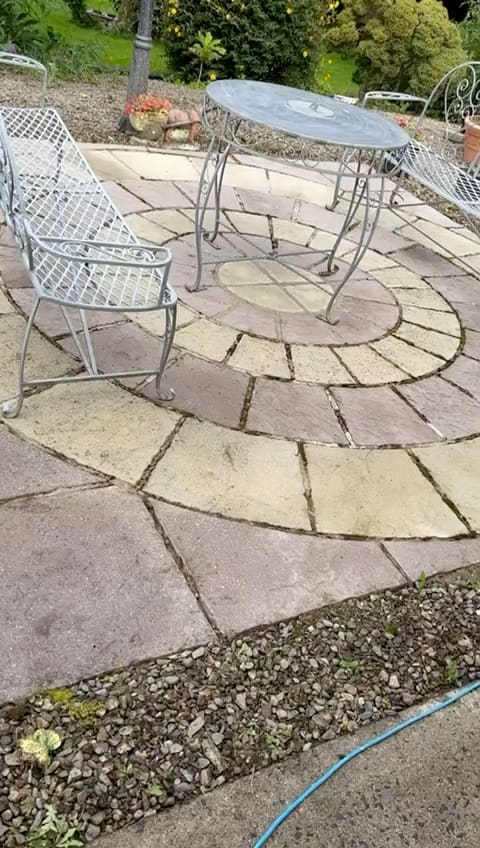 A flagstone patio washed clean, with garden furniture back in place