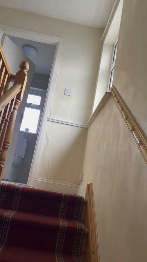 A staircase and landing with a timber handrail